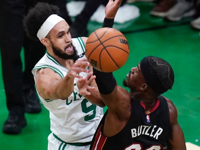 Boston Celtics guard Derrick White (9) passes the ball while pressured by Miami Heat forward Jimmy Butler (22) during the first half of Game 4 of the NBA basketball playoffs Eastern Conference finals, Monday, May 23, 2022, in Boston.